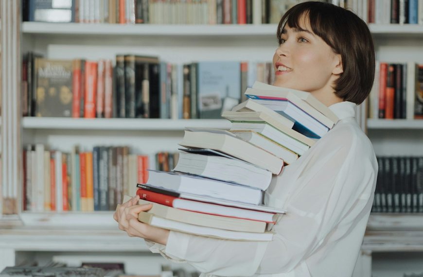Woman carrying a stack of books