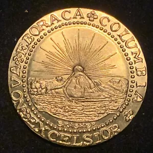 Gold-colored historical coin, features a radiant sun over a seated figure, intricate details, vintage design, possible replica or authentic numismatic piece