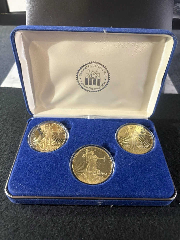 Blue velvet display case with three gold coins, commemorative coin set, reflective gold surfaces, protective coin casing, official certification stamp inside the lid