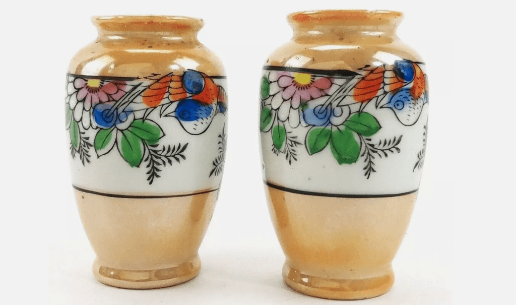 Pair of small vintage ceramic vases, peach-colored base, floral and bird pattern in bright colors, white background