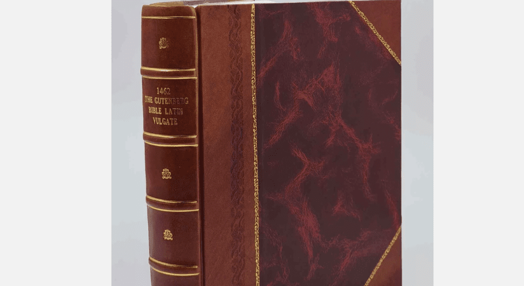 Vintage leather-bound book with red and brown marbled cover, gold trim, embossed spine text in Latin, classic design