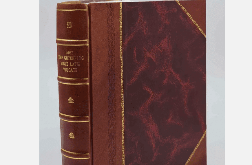 Vintage leather-bound book with red and brown marbled cover, gold trim, embossed spine text in Latin, classic design
