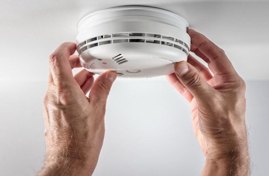 Home smoke and fire alarm detector man installing, maintenance, checking, testing or replacing battery
