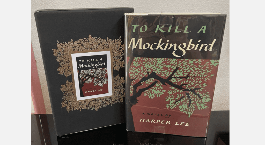 “To Kill a Mockingbird” by Harper Lee, special edition book with slipcase, red and black cover, tree illustration, gold decorative border on box