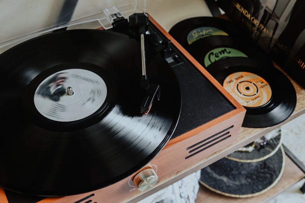 Close-up of a vintage record player, spinning a black vinyl, stacked records nearby, wooden casing, retro setup