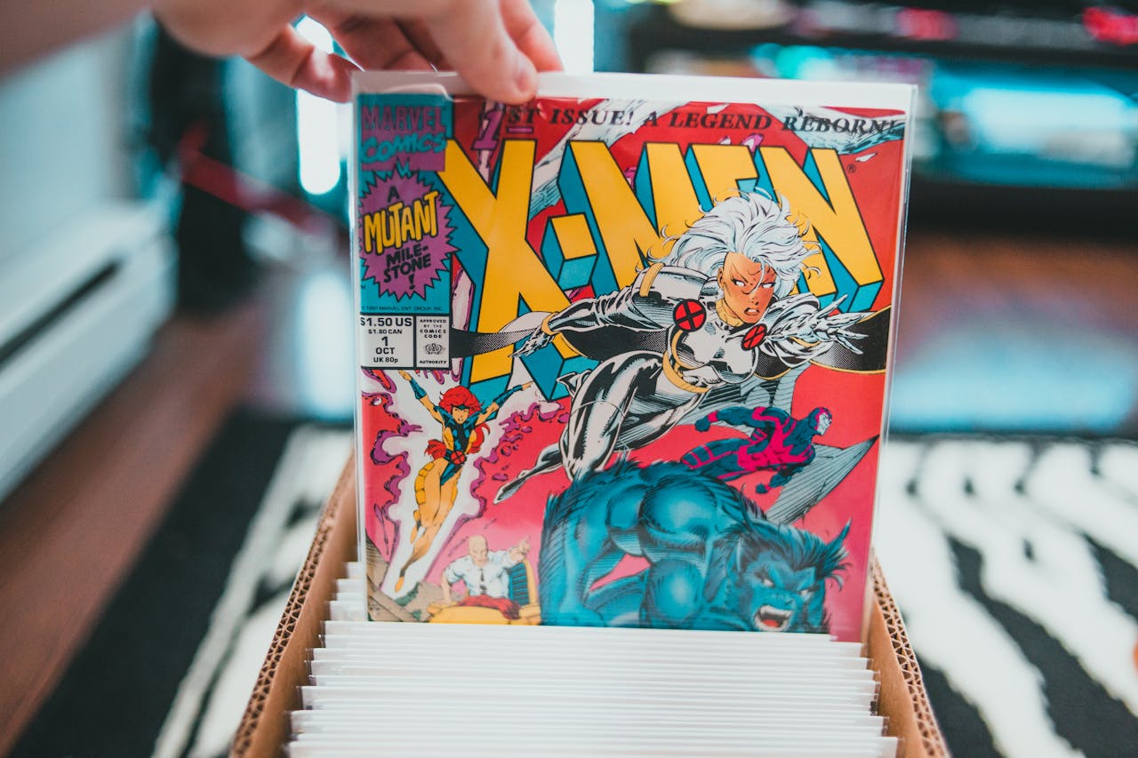 comic book first issue, Hand holding a bagged first issue of Marvel’s X-Men comic, colorful cover with Storm, Wolverine, and Beast, pulled from a comic box