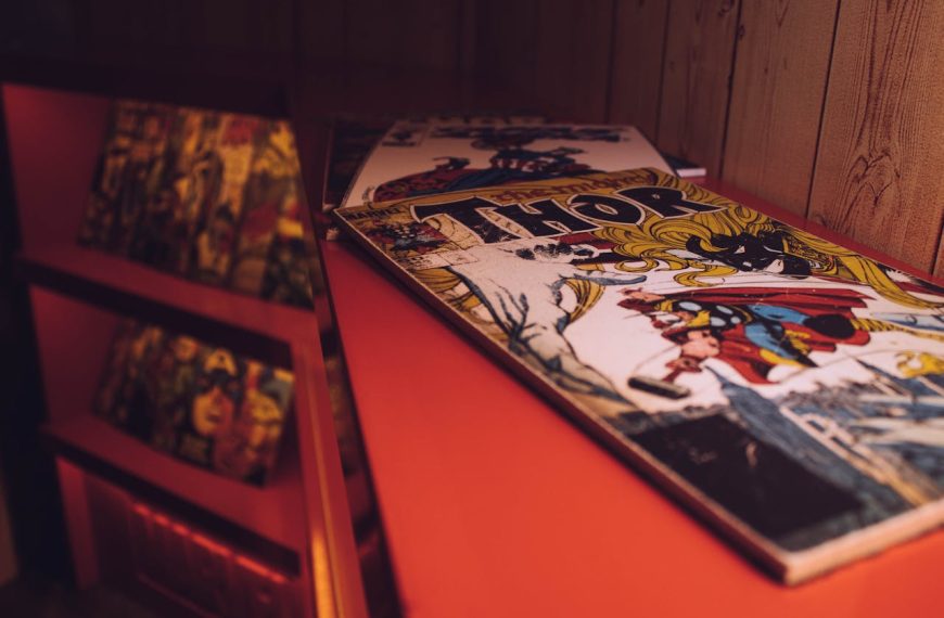 Vintage Thor comic book, Marvel logo visible, placed on red shelf, wood panel wall background, blurred comic display in foreground