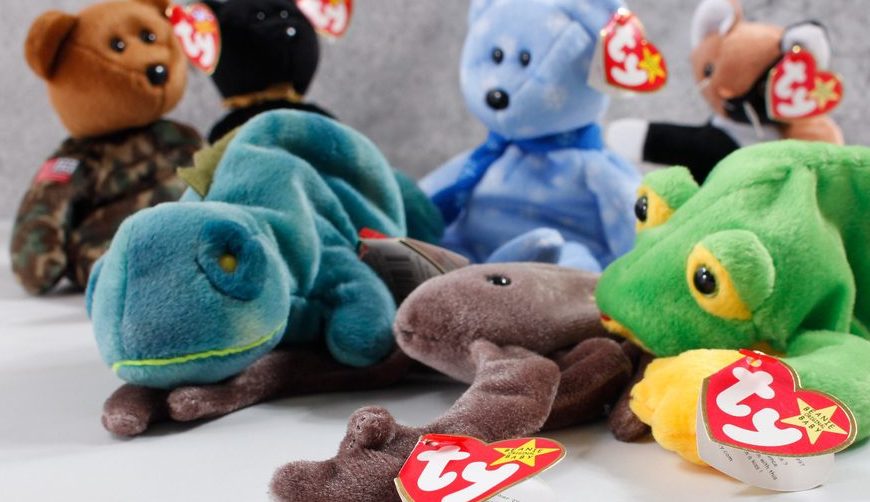 A group of TY Beanie Babies plush toys, including lizards, a bear, and other animals, arranged closely together