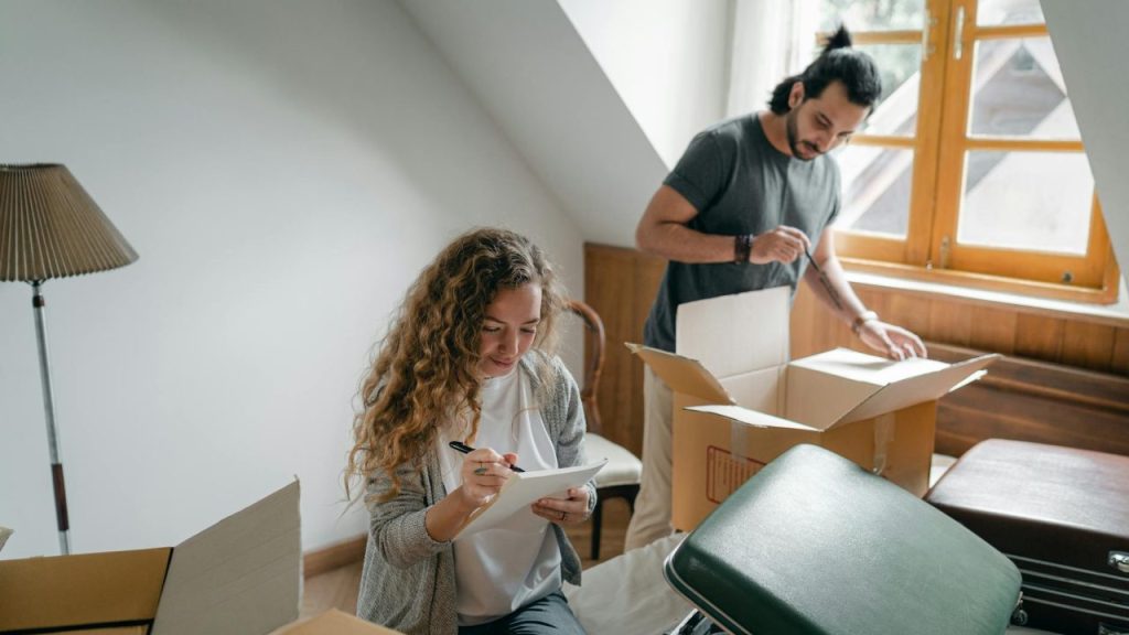 A joyful couple unpacks boxes in their modern, cozy apartment