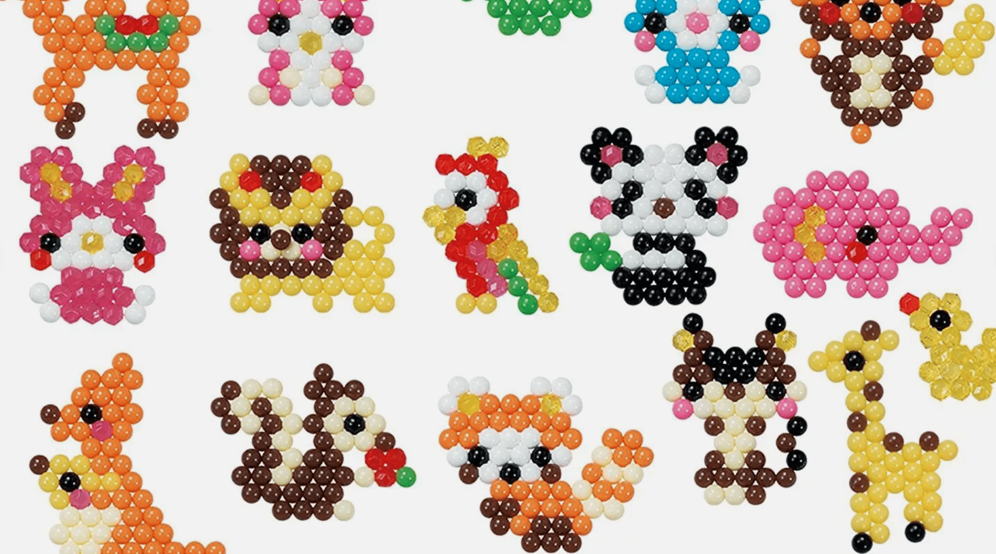 Colorful Aqua Dots arranged into animal shapes including panda, parrot, fox, giraffe, squirrel, and fish, on white background