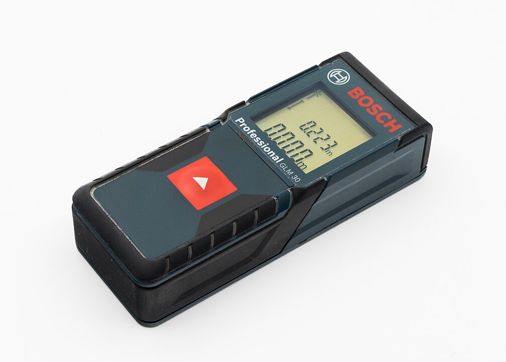 Bosch laser distance measurer, digital display showing measurements in meters and inches, compact rectangular design, large red measurement button, labeled as professional tool