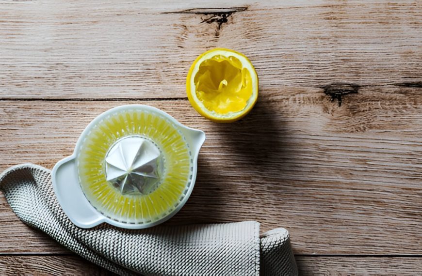 Top view of a juicer with fresh lemon juice. A brown wood table, breakfast.