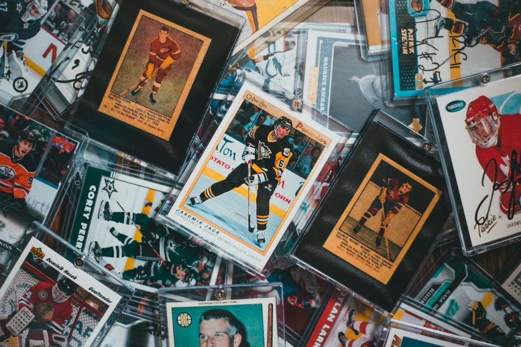 Assorted hockey trading cards in plastic sleeves, featuring vintage and modern players, some autographed, scattered on a flat surface