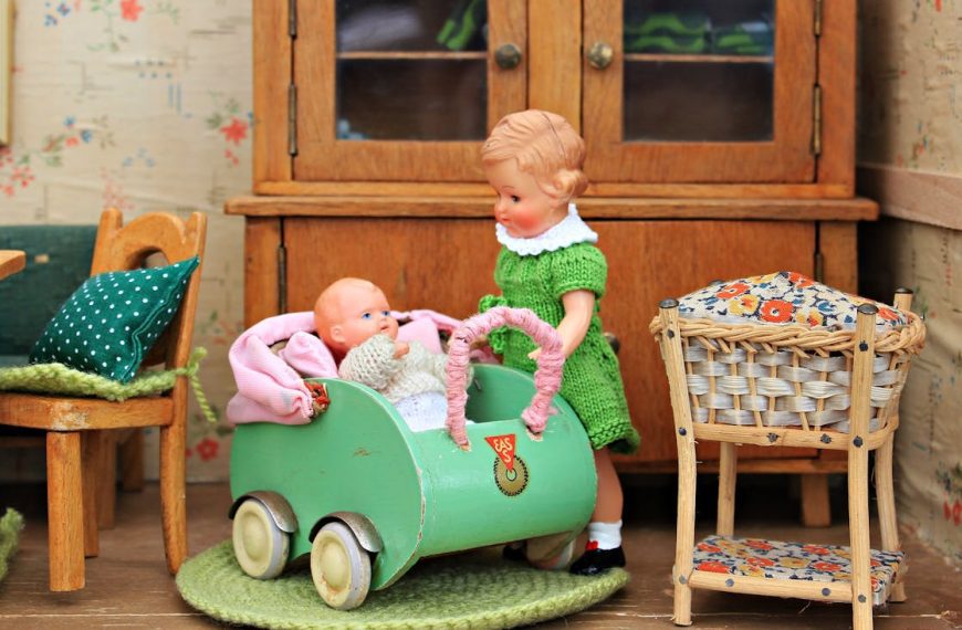 Vintage-style dolls in a miniature room, with a green stroller, wooden furniture, and colorful details creating a cozy scene