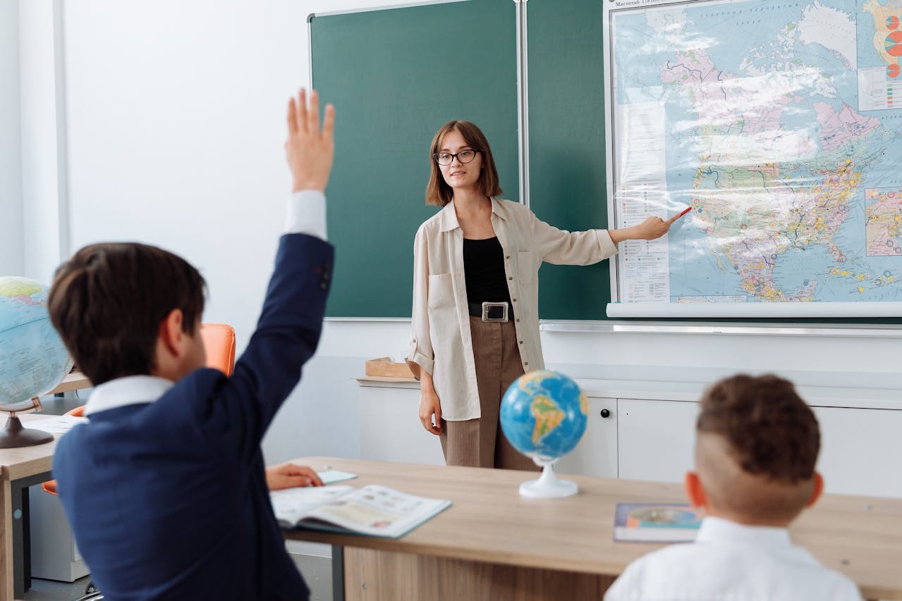 Teacher Discussing Her Lesson while student raising his hand