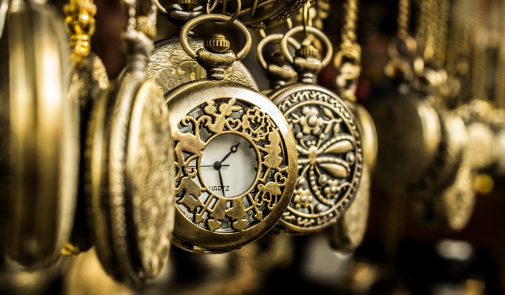 vintage gold pocket watches hanging closely, intricate designs, ornate detailing, classic mechanical clock faces visible