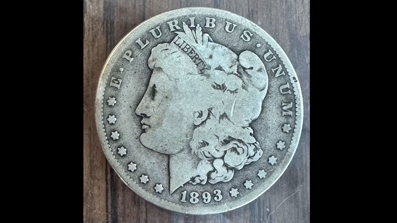 1893 Morgan silver dollar, worn coin showing Liberty’s profile facing left, surrounded by “E PLURIBUS UNUM” and 13 stars