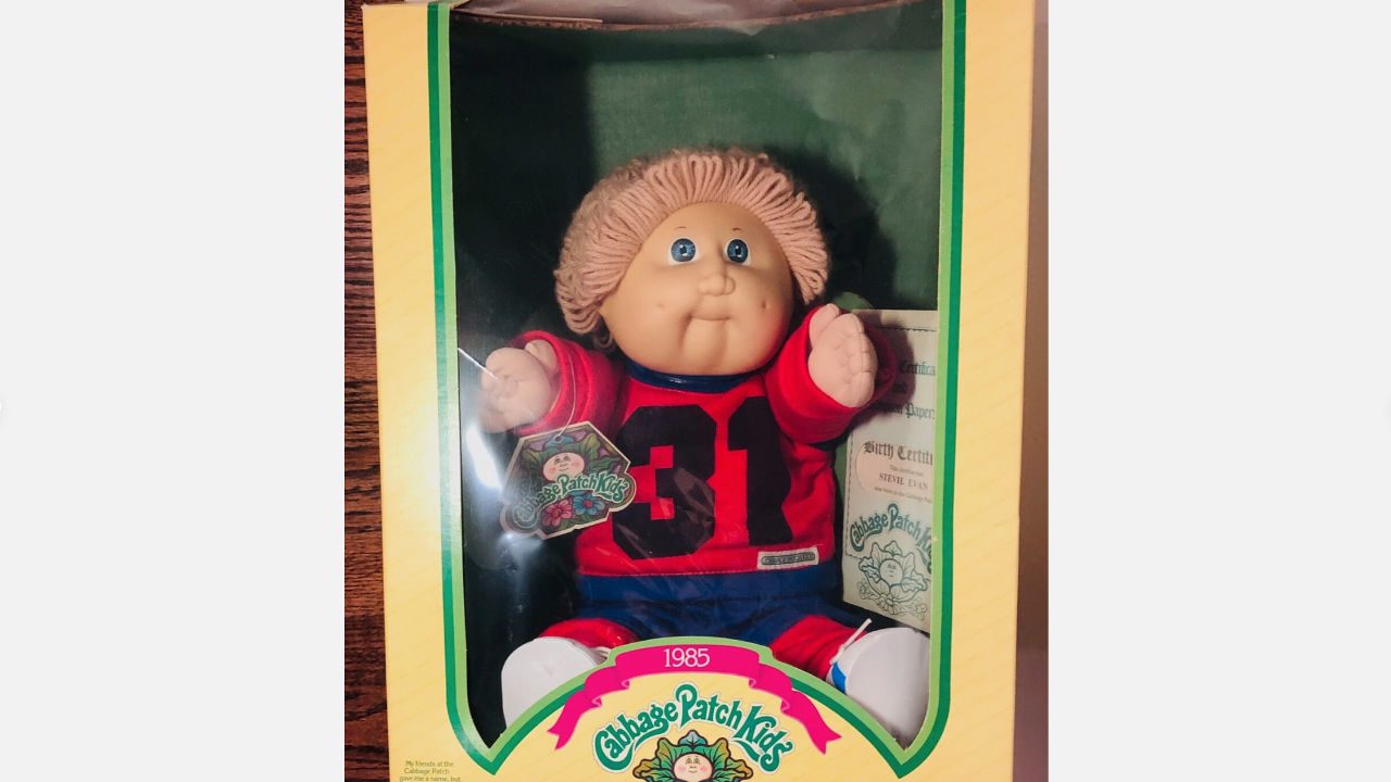 1985 Cabbage Patch Kid doll named James Dudley in original box, wearing a red and blue sports outfit with number 31