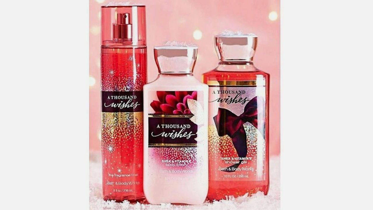 Three Bath & Body Works “A Thousand Wishes” products arranged on a soft, snowy surface with a pink festive background