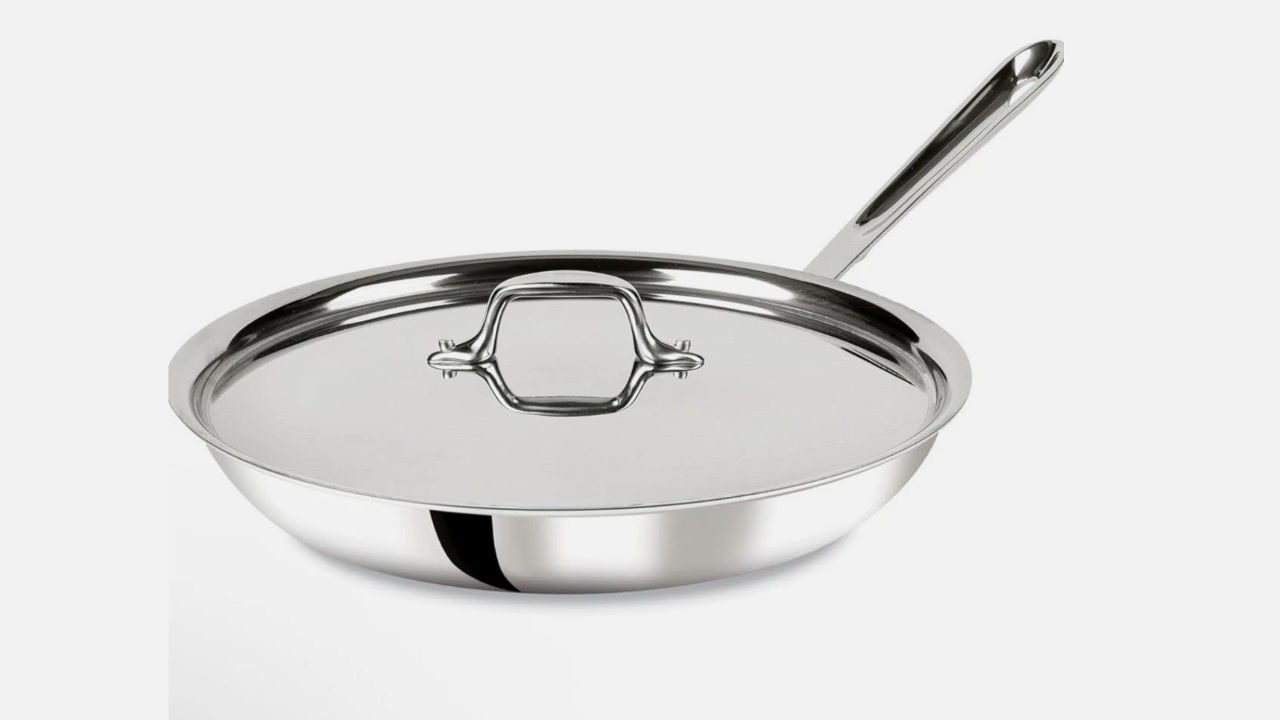 Stainless steel fry pan with lid and long handle, placed on a white background