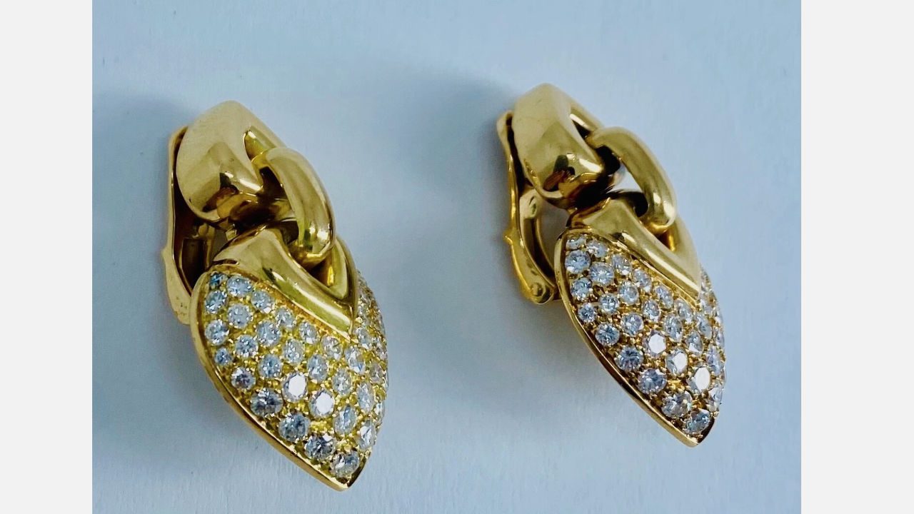 Pair of gold Bulgari Doppio Cuore earclips, featuring interlocking heart-shaped designs encrusted with round brilliant diamonds