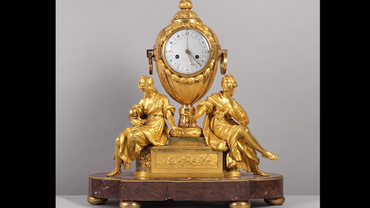 Ornate French mantel clock, gilded bronze with Roman numeral dial, urn-shaped centerpiece, two seated female sculptures in classical robes, mounted on oval marble base with decorative feet