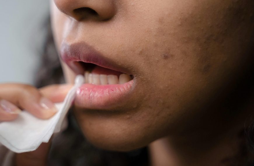 Woman wiping and cleaning makeup off mouth during beauty routine