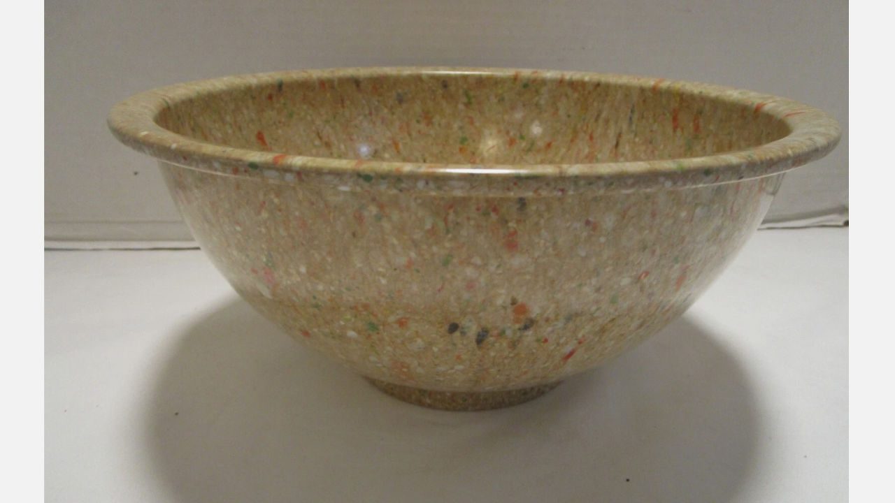 Vintage confetti melamine bowl with multicolored specks on a beige background, wide rim and rounded shape