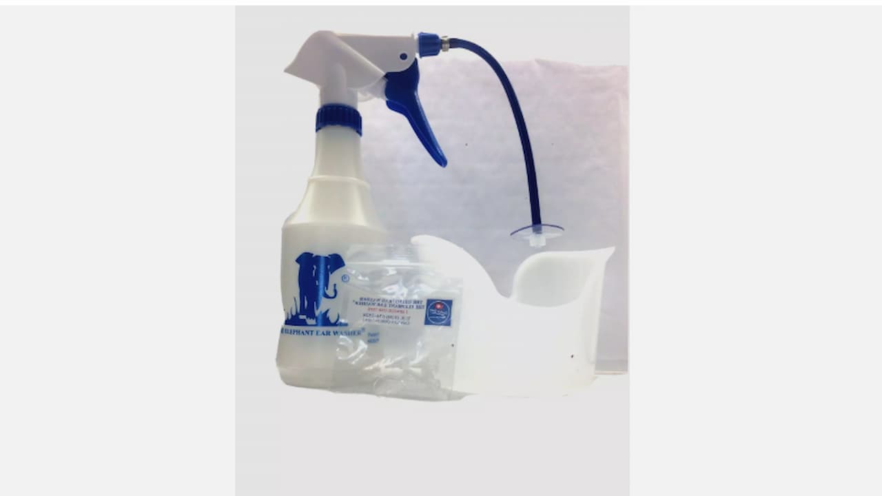 Elephant ear washer kit with spray bottle, attached blue hose, ear basin, and cleaning solution packet, placed against a white background