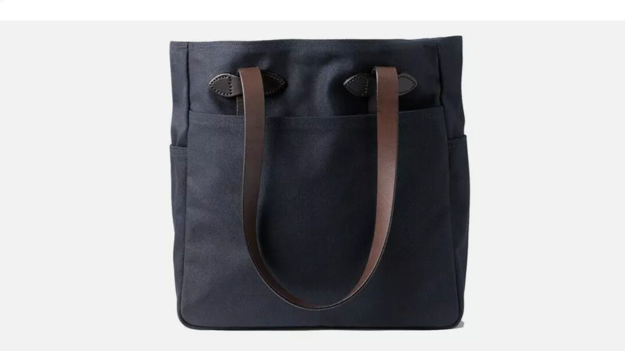 Black rugged twill tote bag with two brown leather shoulder straps and exterior side pockets