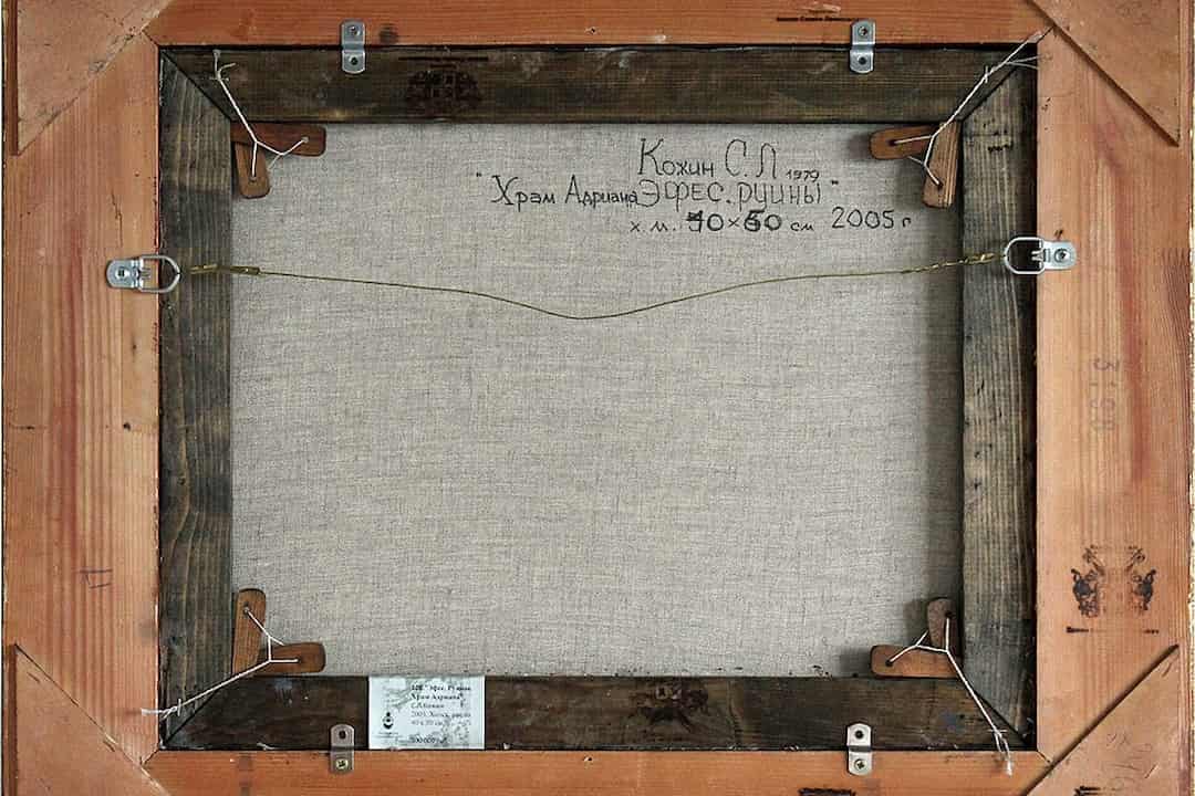 Back view of a framed canvas painting, showing wooden stretcher bars, mounting hardware, and handwritten details including artist name, title, dimensions, and date