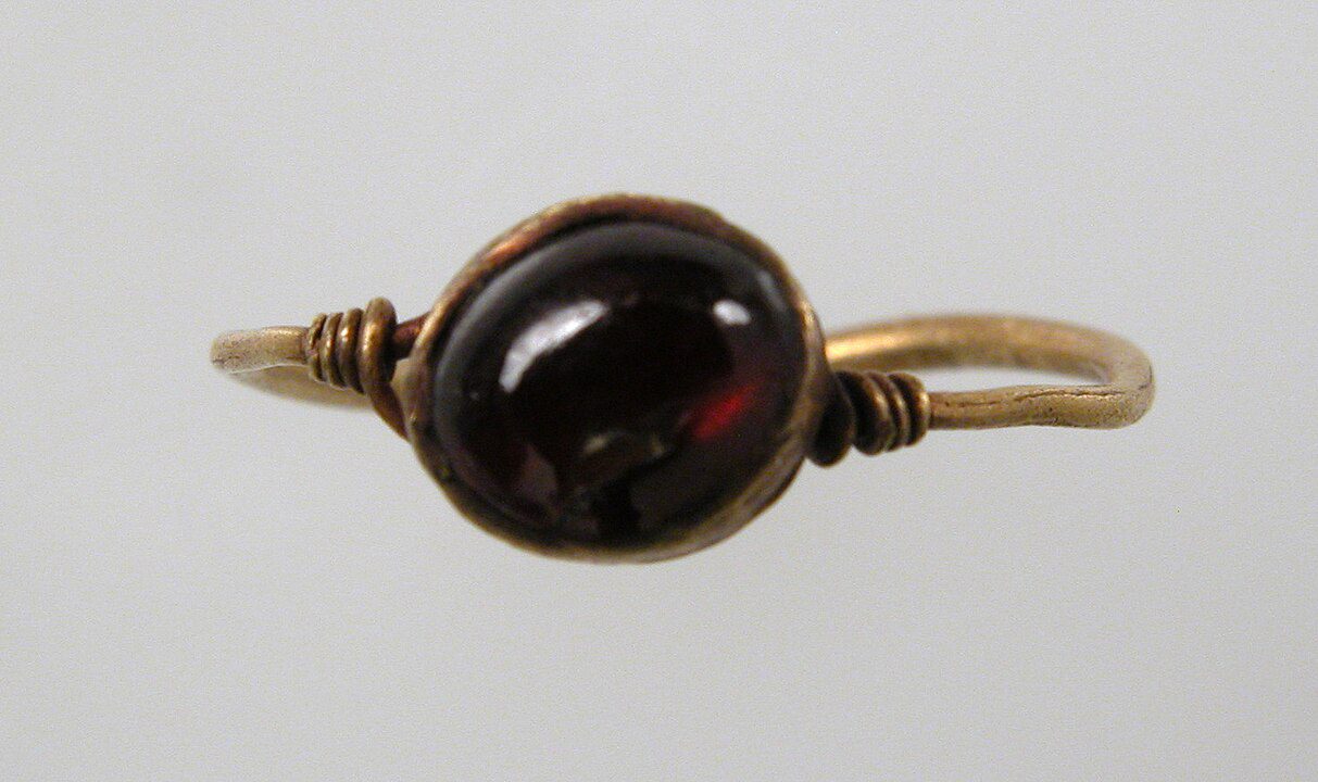Vintage gold ring, dark red oval gemstone, wire-wrapped design, minimalist antique style, plain white background