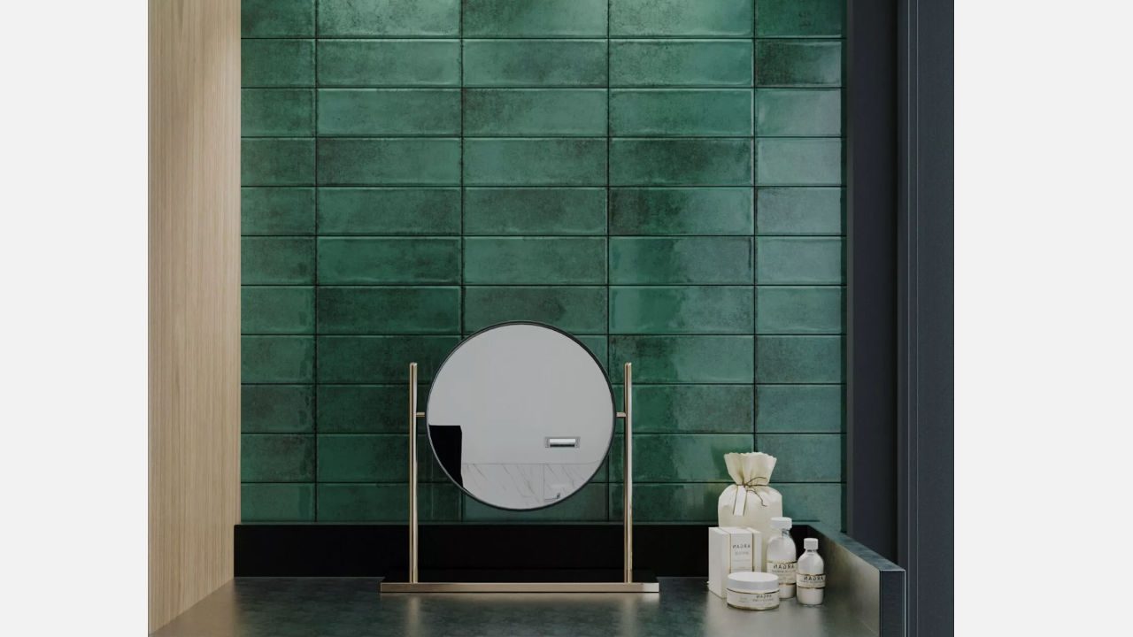 Modern vanity setup with a round mirror on a metal stand, green subway tile backsplash, and neatly arranged skincare products