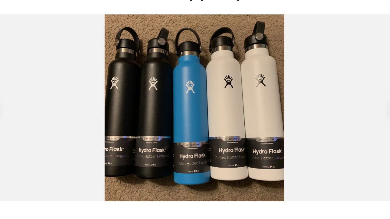 Five Hydro Flask water bottles in black, blue, and white, with flip-top lids, arranged side by side