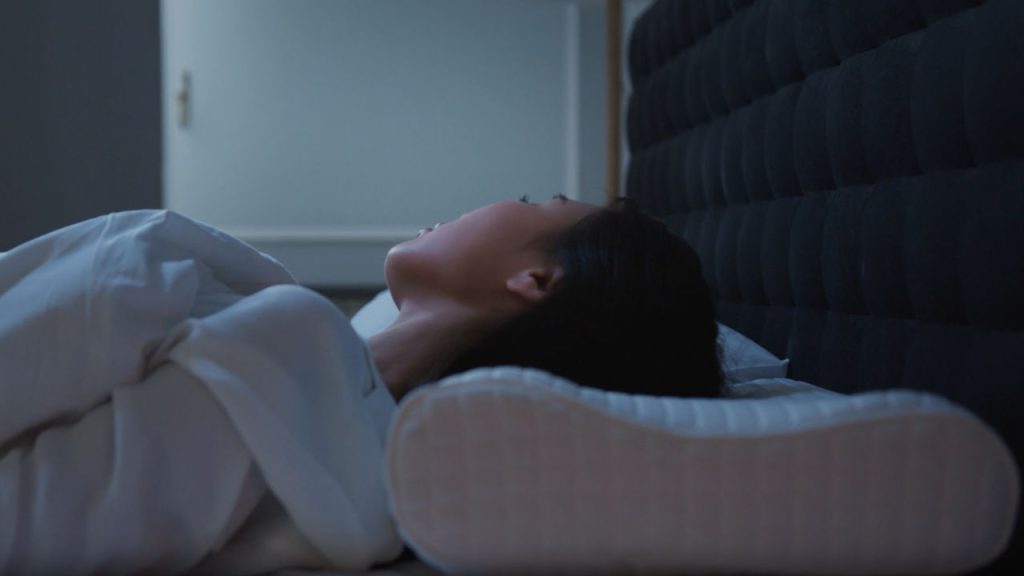 Peaceful nighttime rest, memory foam pillow advertisement, neck support demonstration, comfortable sleep setup, nighttime relaxation, orthopedic pillow