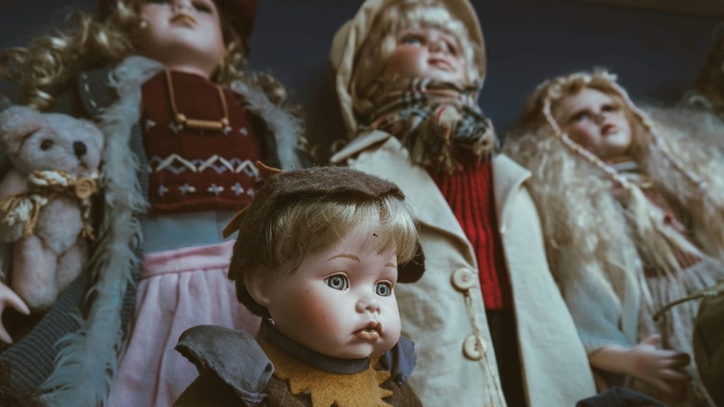 Porcelain Dolls, Group of vintage porcelain dolls, dressed in old-fashioned winter clothes, blank expressions, dramatic lighting