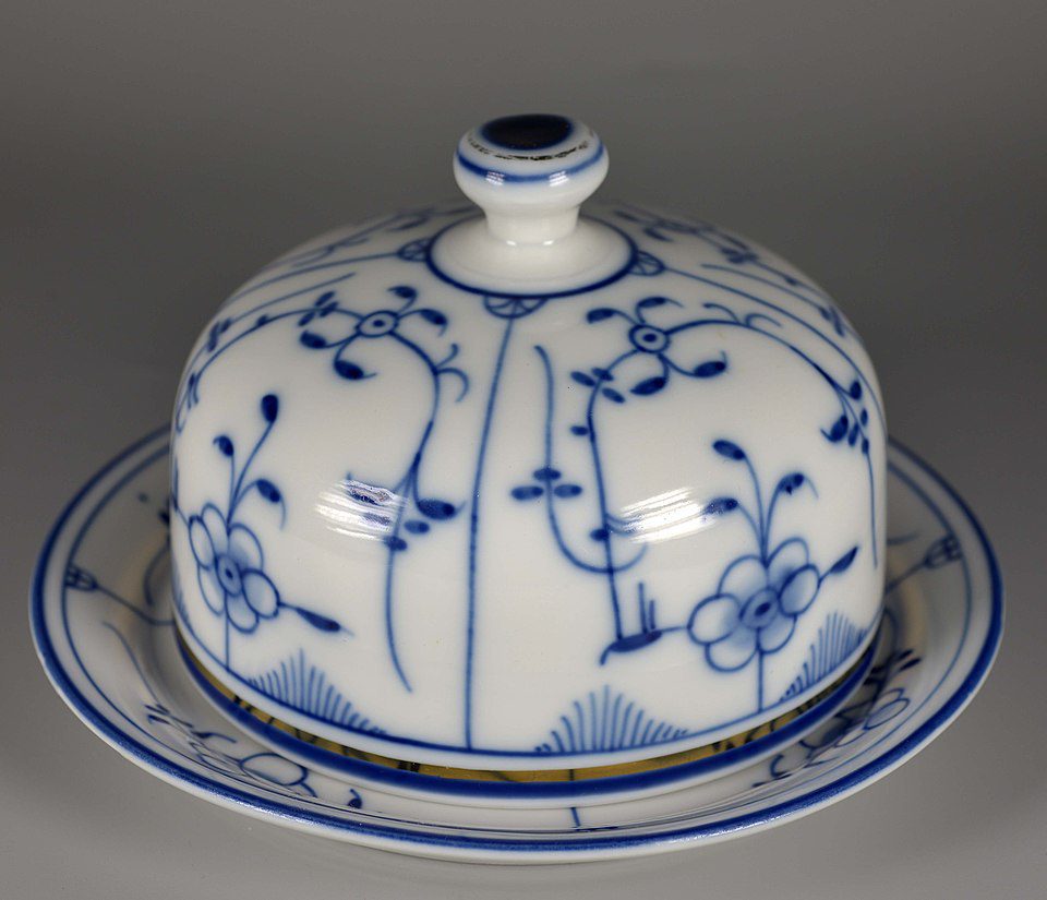 Blue and white porcelain butter dish, floral vine pattern, domed lid with knob handle, matching base plate, traditional ceramic design