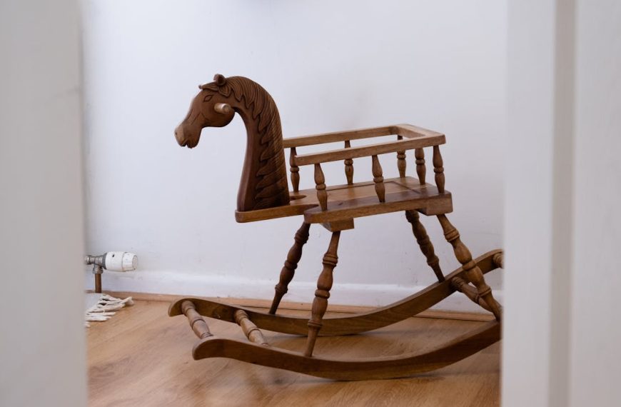 wooden rocking horse, vintage design, placed on wooden floor, white walls in background