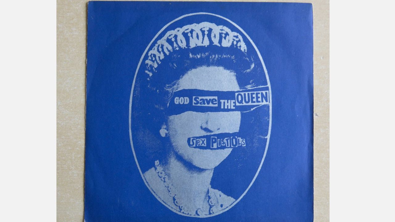 Sex Pistols "God Save the Queen" rare pink vinyl sleeve, featuring a blue cover with a stylized portrait of Queen Elizabeth II with text cutouts reading "God Save the Queen"