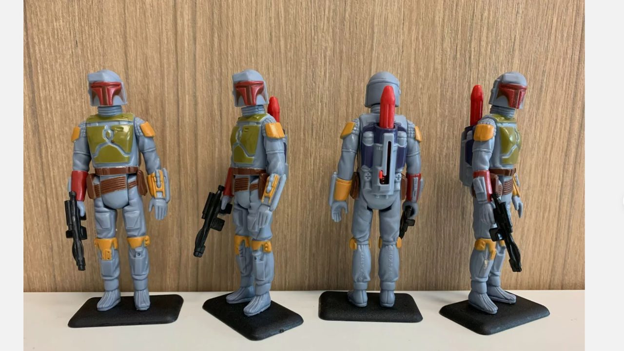 Four vintage 1979 Star Wars Boba Fett action figures with rocket-firing backpacks and blasters, posed on black stands