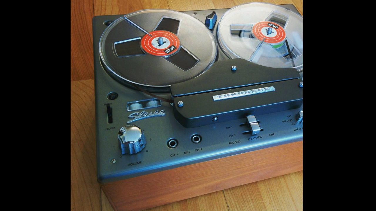 Vintage Tandberg reel-to-reel tape recorder with wood casing, dual BASF tape reels, and retro stereo controls