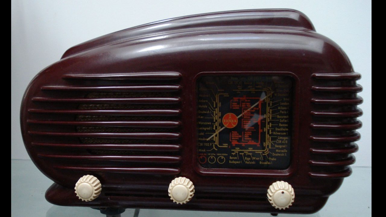 Vintage Tesla Model 308U “Talisman” radio with dark maroon Bakelite casing, horizontal grille slats, world map tuning dial, and three cream-colored knobs