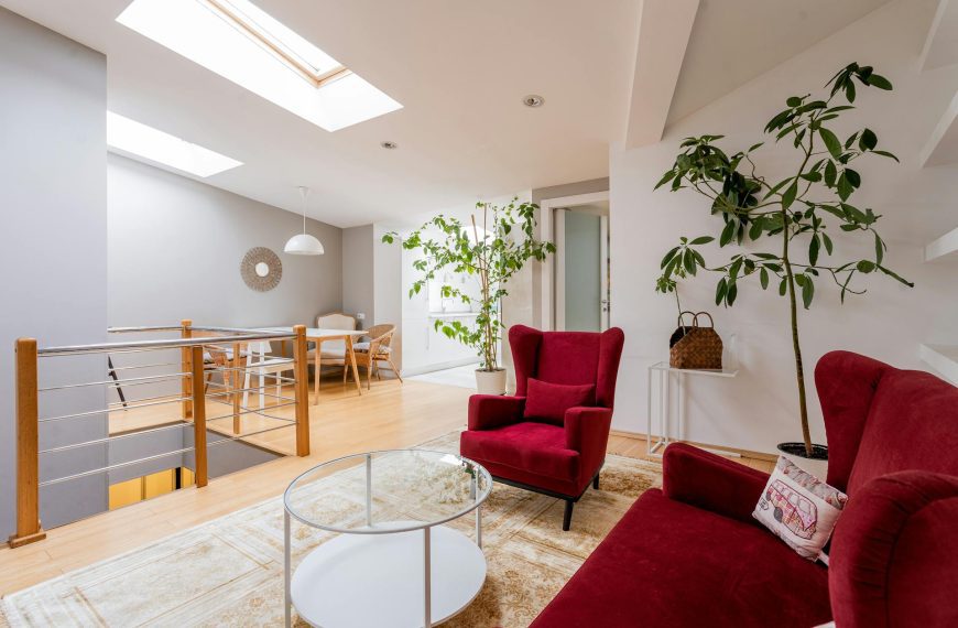 Interior of a Modern Living Room with a Red Sofa and Armchair skylight