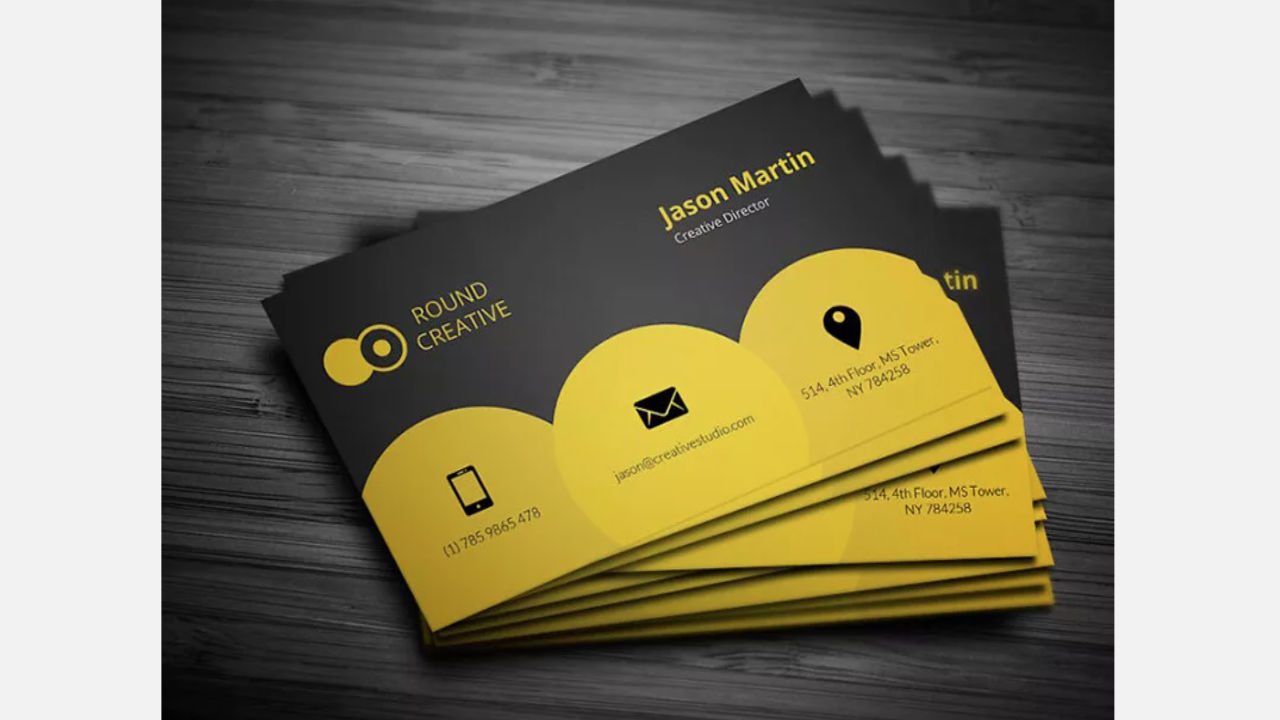 Stack of modern black and yellow business cards with contact icons, company name "Round Creative," and details for Jason Martin, Creative Director