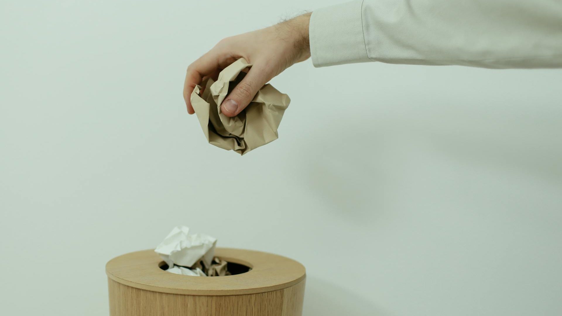 Close Up Photo Of Person Throwing Paper Into A Trash Bin