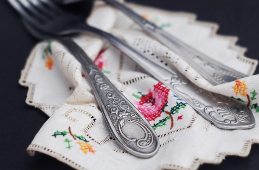 Napkins embroidered with floral designs under silverware
