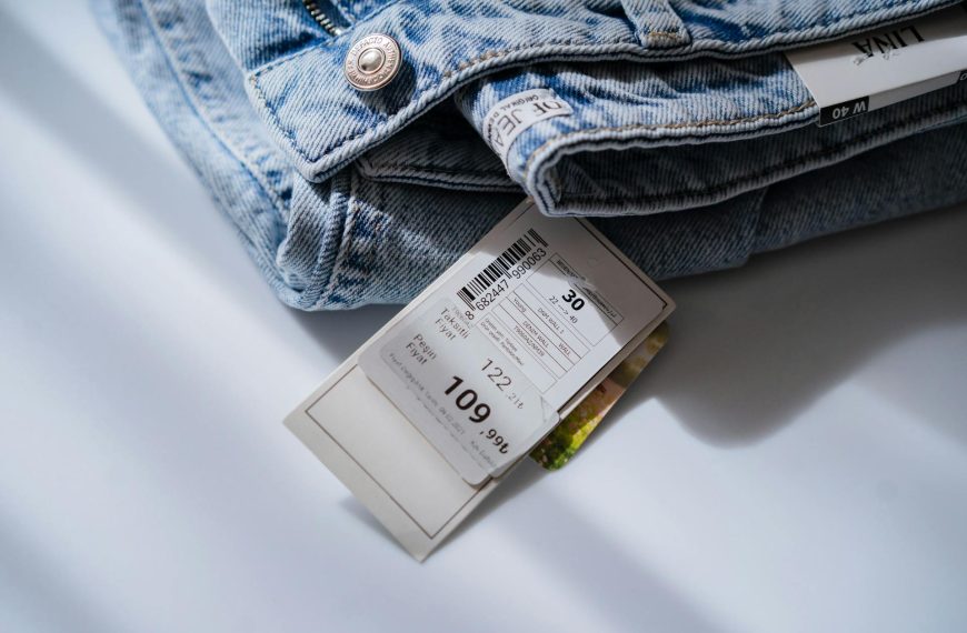 Jeans with price ticket on white table