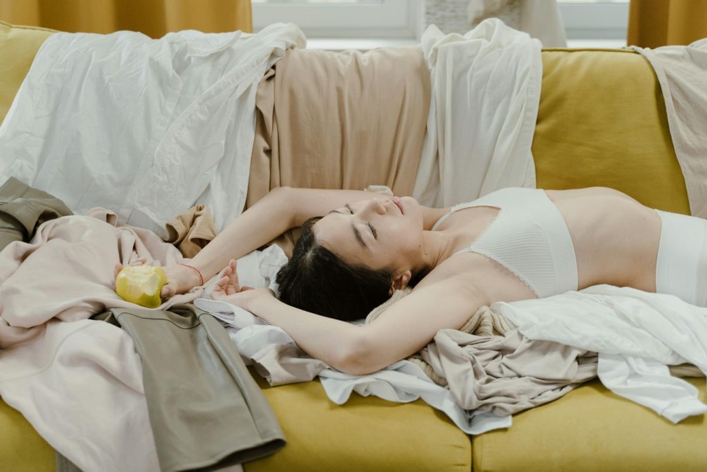 Woman Lying on a Couch Holding a Green Apple