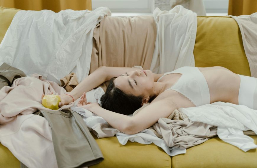 Woman Lying on a Couch Holding a Green Apple