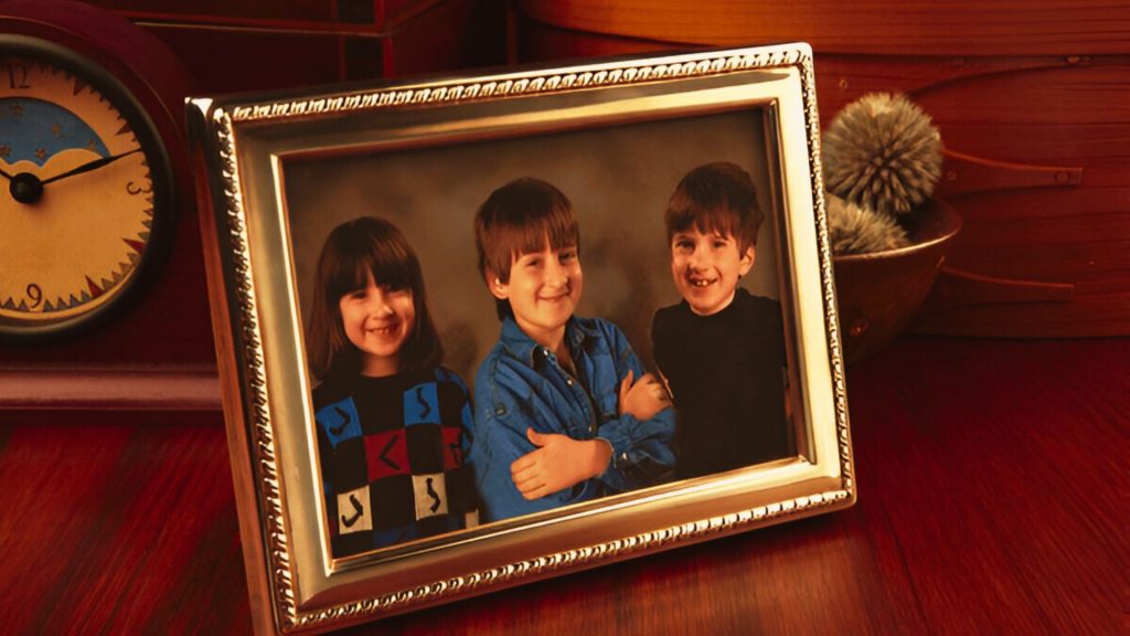 childhood ornate gold frames Framed photo on wooden desk of three smiling children